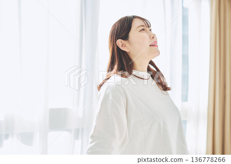 一位女士深吸一口氣，在晨光中放鬆身心。 136778266