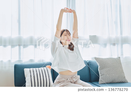 A woman taking a deep breath and relaxing in natural morning light 136778270