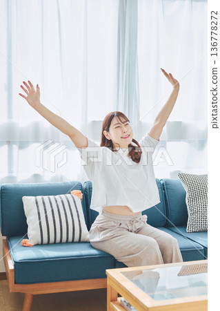 A woman taking a deep breath and relaxing in natural morning light 136778272