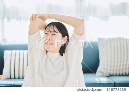 一位女士深吸一口氣，在晨光中放鬆身心。 136778289
