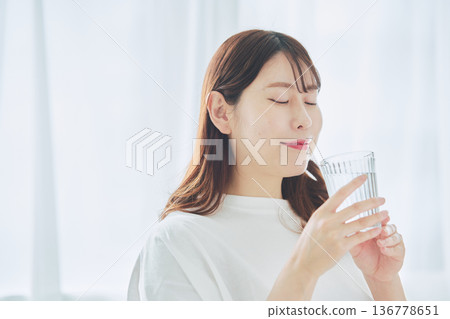 Daily life of a woman drinking water while relaxing 136778651