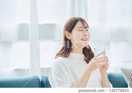 一位女性在放鬆時喝水的日常生活 一位女性在放鬆時喝水的日常生活 136778653