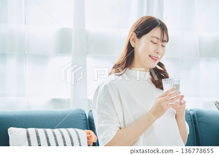 一位女性在放鬆時喝水的日常生活 一位女性在放鬆時喝水的日常生活 136778655
