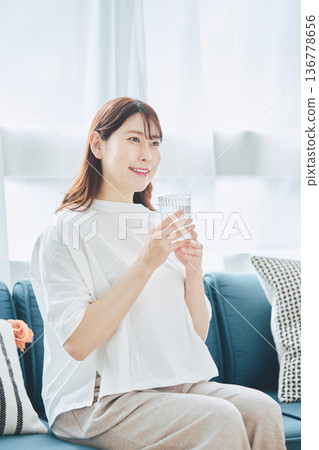 一位女性在放鬆時喝水的日常生活 136778656