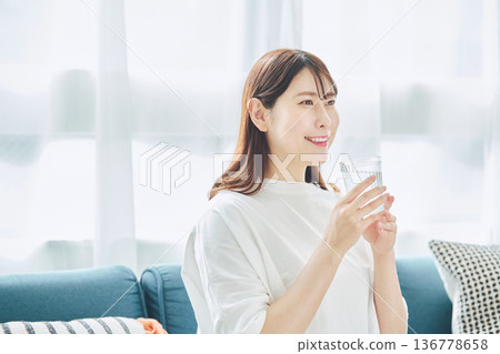 一位女性在放鬆時喝水的日常生活 136778658