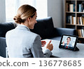 Young caucasian female professional having a video call in modern office setting 136778685
