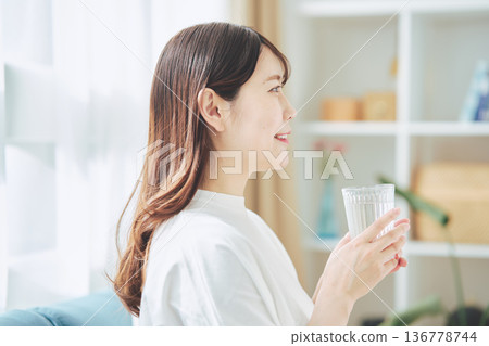 一位女性在放鬆時喝水的日常生活 一位女性在放鬆時喝水的日常生活 136778744