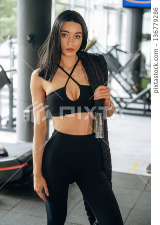 Standing and holding knots. Beautiful woman is at the gym Standing and holding knots. Beautiful woman is at the gym 136779286