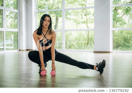 Woman is doing fitness indoors Woman is doing fitness indoors 136779292
