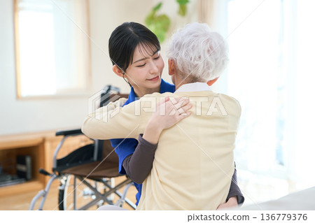Asian caregiver assisting with transfer during home care visit 136779376