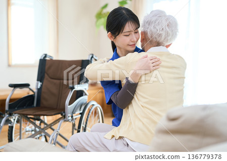 一位亞裔護理員在家庭護理探訪期間協助轉移。 136779378