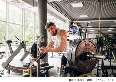 Strong man is working out in the gym Strong man is working out in the gym 136779574
