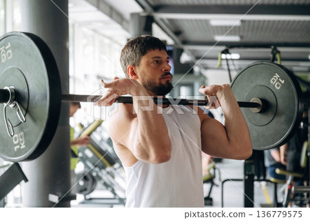 Back squat exercise. Strong man is working out in the gym 136779575