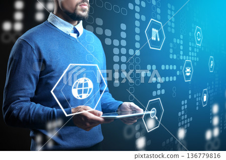 Person using tablet with digital icons on screen in a tech-focused setting at daytime Person using tablet with digital icons on screen in a tech-focused setting at daytime 136779816