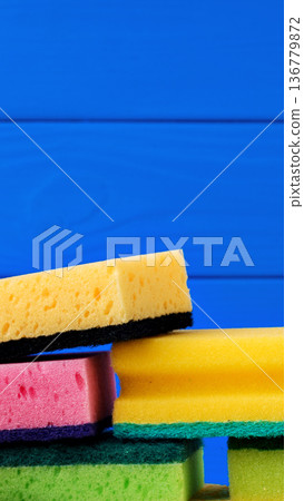 Colorful sponges stacked on a blue wooden surface during daytime Colorful sponges stacked on a blue wooden surface during daytime 136779872