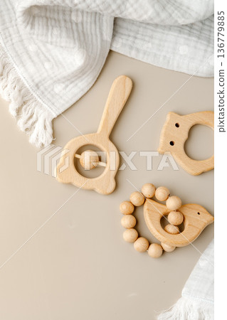 Wooden baby toys are placed on a light surface with a soft cloth nearby Wooden baby toys are placed on a light surface with a soft cloth nearby 136779885
