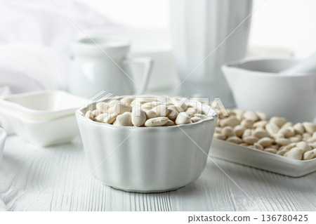 Dried white beans on a white table. 136780425