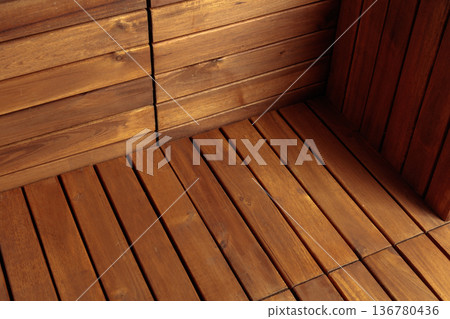 Table and walls made of brown wooden slats. 136780436