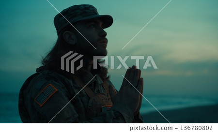 Silhouette of an American soldier praying for veteran to God on the beach night Silhouette of an American soldier praying for veteran to God on the beach night 136780802
