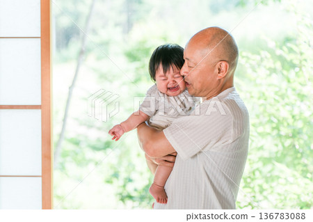 Grandpa holds baby struggling to get along with grandson Grandpa holds baby struggling to get along with grandson 136783088