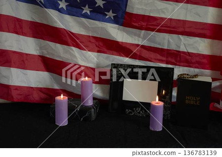 funeral an American hero, photo frame, candles, marble urn for ashes, holy bible and spiritual bracelet with black cross 136783139