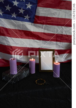 funeral an American hero, photo frame, candles, marble urn for ashes, holy bible and spiritual bracelet with black cross 136783146