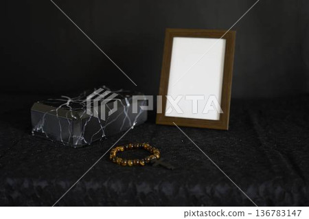 funeral, a photo frame, candles, marble urn for ashes, spiritual bracelet with black cross 136783147