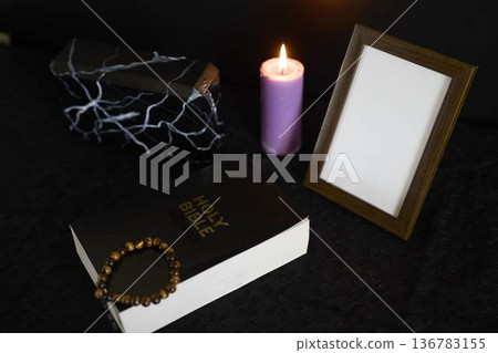 funeral, photo frame, candles, a marble urn for ashes, holy bible and spiritual bracelet with black cross 136783155
