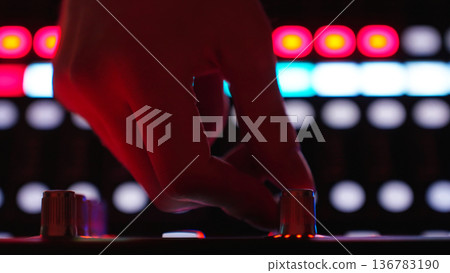 Closeup Hand Sound Engineer Rotates Knob, Audio Mixer Reacts. Studio Production, Concert Sound Adjustment, Recording Studio. Closeup Hand Sound Engineer Rotates Knob, Audio Mixer Reacts. Studio Production, Concert Sound Adjustment, Recording Studio. 136783190