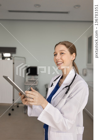 Female nurse or GP working on digital tablet at workplace Female nurse or GP working on digital tablet at workplace 136783351