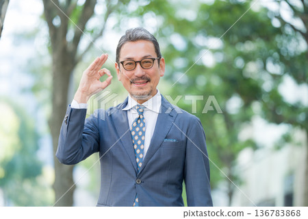 A businessman outdoors saying OK A businessman outdoors saying OK 136783868