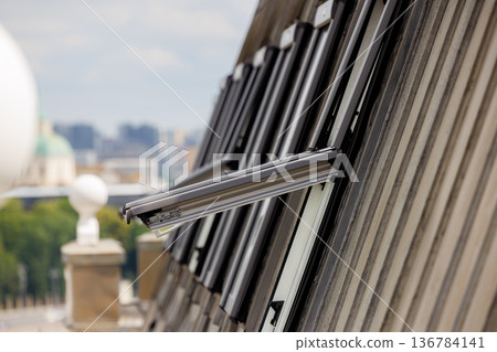 Windows ajar on a modern building during a clear day in the city skyline Windows ajar on a modern building during a clear day in the city skyline 136784141
