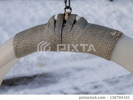 Fishing ring suspended by sturdy rope against a snowy backdrop at dawn 136784181