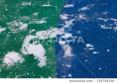 Colorful playground surface with scattered snow in a quiet winter scene Colorful playground surface with scattered snow in a quiet winter scene 136784190