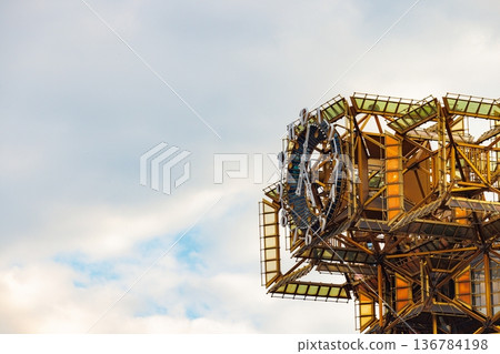 Glistening metal structure reflects the sky at dusk in an artistic display of modern engineering 136784198