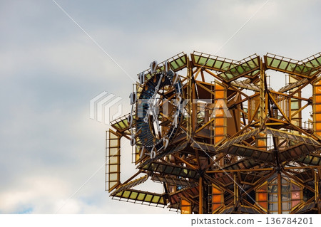 Exploration of a unique architectural structure with vibrant colors under a cloudy sky Exploration of a unique architectural structure with vibrant colors under a cloudy sky 136784201