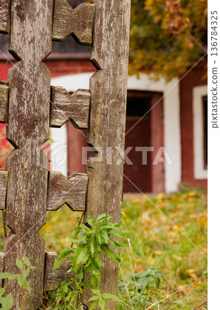 Rustic wooden fence highlights autumn colors at an old farmhouse in the countryside Rustic wooden fence highlights autumn colors at an old farmhouse in the countryside 136784325