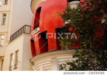 Unique red-tiled building with distinct architectural features in an urban setting Unique red-tiled building with distinct architectural features in an urban setting 136784366