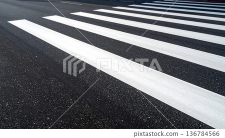 An empty urban asphalt road features white lane lines and a yellow arrow symbol painted on the tarmac to guide city traffic and pedestrian crossing transportation 136784566