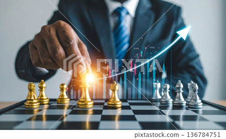 A successful businessman holding a trophy and a growth graph leads his team to checkmate in a strategic battle on the chessboard 136784751