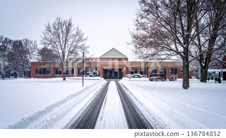 A scenic winter landscape featuring a frost covered house and snow covered bridge along a frozen city street under a blue sky A scenic winter landscape featuring a frost covered house and snow covered bridge along a frozen city street under a blue sky 136784852