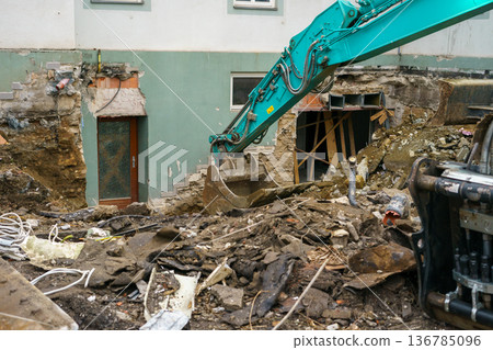 Single excavator demolishing an old building at construction site,clearing debris for urban redevelopment,renovation or infrastructure renewal project 136785096