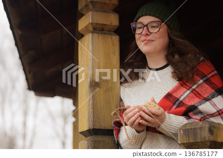 Enjoying a cozy moment with a small creature on a chilly winter day at a rustic cabin 136785177