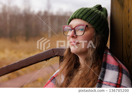 Exploring nature's beauty while wrapped in comfort on a serene autumn day 136785200