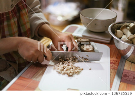 Woman cutting mushrooms Woman cutting mushrooms 136785539