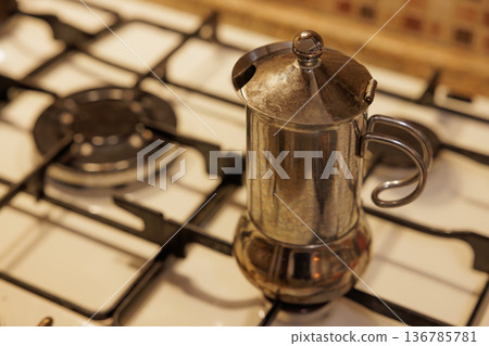 Brewing rich coffee in an elegant moka pot on a cozy stovetop Brewing rich coffee in an elegant moka pot on a cozy stovetop 136785781