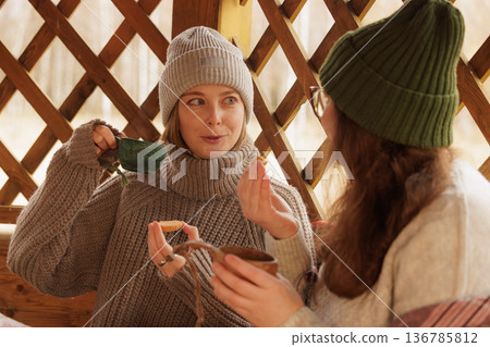 Enjoying warm beverages and cozy moments on a chilly day in a rustic cabin Enjoying warm beverages and cozy moments on a chilly day in a rustic cabin 136785812