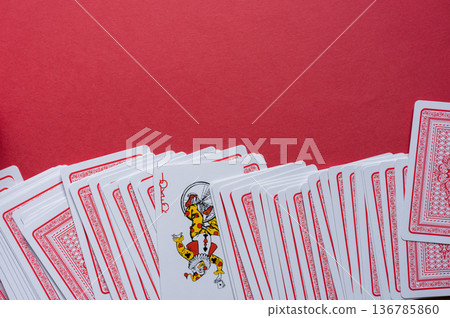 Playing cards lined up on a red background 136785860