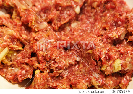 Freshly prepared ground meat ready for cooking in a lively kitchen setting Freshly prepared ground meat ready for cooking in a lively kitchen setting 136785929