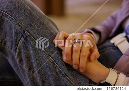 Hands intertwined in a moment of connection during a cozy gathering at a warm, inviting space 136786124